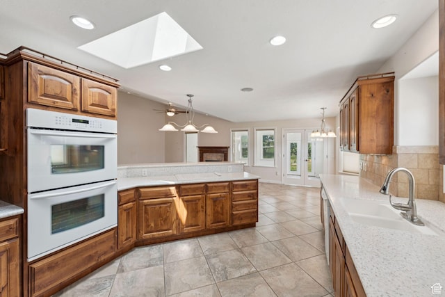 2828 W Gentile St, Layton, UT 84041 - kitchen with double oven, a skylight, light countertops, a peninsula, and recessed lighting