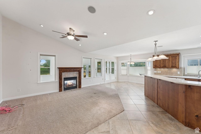 2828 W Gentile St, Layton, UT 84041 - kitchen featuring brown cabinetry, light countertops, a tile fireplace, decorative backsplash, and pendant lighting