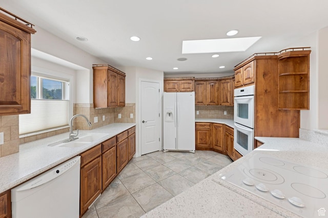 2828 W Gentile St, Layton, UT 84041 - kitchen with white appliances, a skylight, open shelves, brown cabinetry, and backsplash