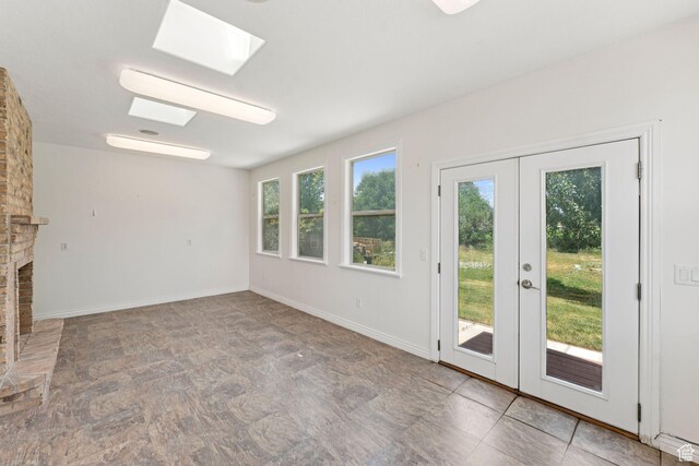 2828 W Gentile St, Layton, UT 84041 - unfurnished living room with french doors, a skylight, stone finish floors, and a fireplace