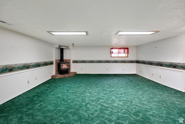 421 S 90 W, Richmond, UT 84333 - below grade area featuring a wood stove, a textured ceiling, carpet floors, and a wainscoted wall