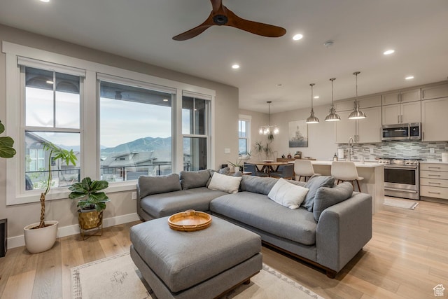 11721 N Shoreline Dr, Hideout, UT 84036 - living area featuring light wood-type flooring, a ceiling fan, recessed lighting, a chandelier, and a mountain view