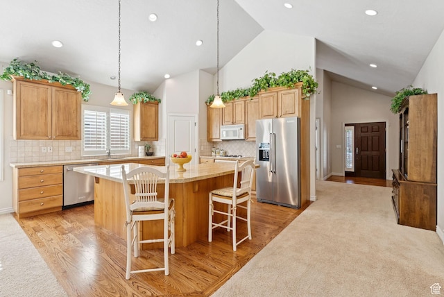 1369 E Farm Dr, Murray, UT 84117 - kitchen featuring stainless steel appliances, a kitchen island, light wood-style flooring, a kitchen bar, and high vaulted ceiling