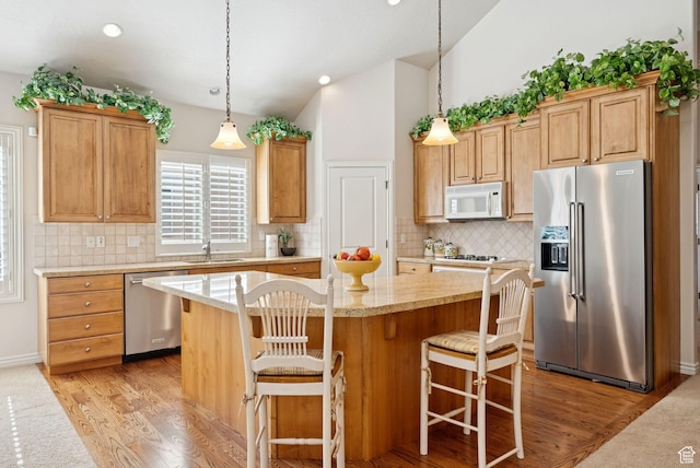 1369 E Farm Dr, Murray, UT 84117 - kitchen featuring stainless steel appliances, light wood-style floors, a center island, tasteful backsplash, and pendant lighting