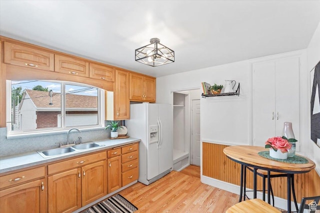 535 W Fern Dr, Midvale, UT 84047 - kitchen with white fridge with ice dispenser, light countertops, light wood-style flooring, decorative backsplash, and a wainscoted wall