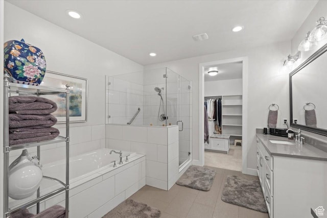 6221 W Applecross Cir, Highland, UT 84003 - bathroom featuring vanity, a garden tub, a stall shower, a walk in closet, and tile patterned flooring
