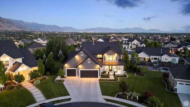 6221 W Applecross Cir, Highland, UT 84003 - view of front of house with concrete driveway, board and batten siding, a mountain view, and a front yard