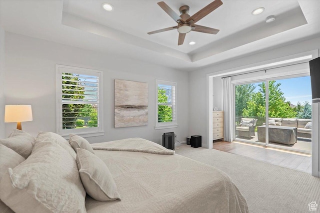 6221 W Applecross Cir, Highland, UT 84003 - bedroom featuring access to exterior, a tray ceiling, multiple windows, recessed lighting, and wood finished floors