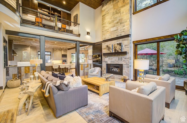 4896 Last Stand Dr, Snyderville, UT 84098 - living area with a high ceiling, a stone fireplace, wood finished floors, wood ceiling, and healthy amount of natural light