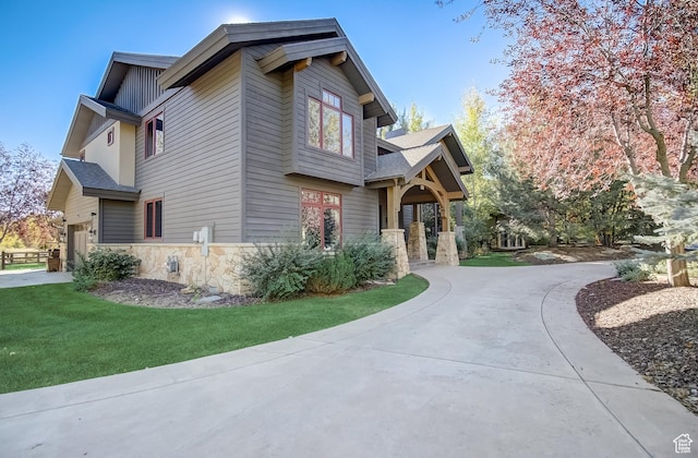 4896 Last Stand Dr, Snyderville, UT 84098 - view of side of property with stone siding, curved driveway, a garage, a yard, and board and batten siding