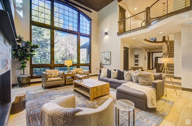 4896 Last Stand Dr, Snyderville, UT 84098 - living room featuring a high ceiling, hardwood / wood-style floors, stairs, healthy amount of natural light, and a fireplace with raised hearth