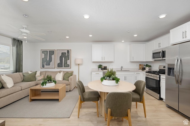 212 N Loring Ave W Unit 115, Santaquin, UT 84655 - kitchen featuring stainless steel appliances, open floor plan, white cabinets, light wood finished floors, and recessed lighting