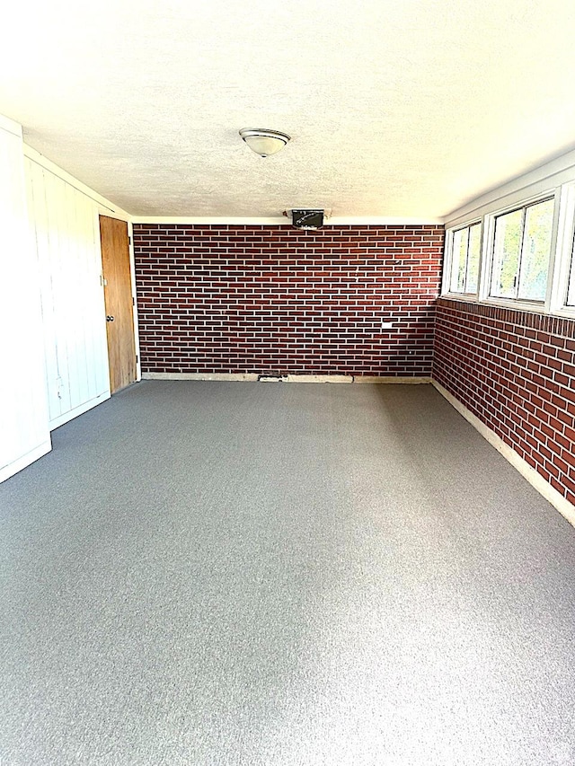 615 E Ben Lomond Ave, South Ogden, UT 84403 - unfurnished room featuring brick wall and a textured ceiling