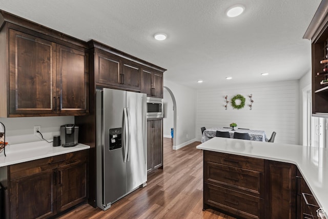 332 E 2475 N, North Logan, UT 84341 - kitchen with appliances with stainless steel finishes, arched walkways, dark wood finished floors, dark brown cabinets, and recessed lighting