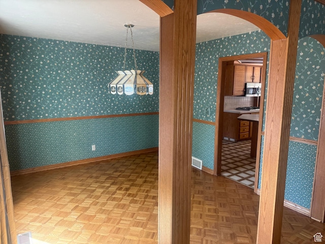 2650 E Willow Wick Dr, Sandy, UT 84093 - unfurnished dining area featuring arched walkways and wallpapered walls