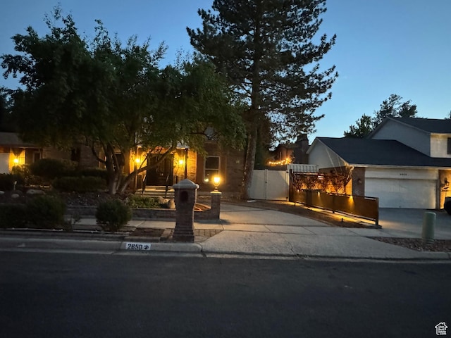 2650 E Willow Wick Dr, Sandy, UT 84093 - view of property hidden behind natural elements with concrete driveway, a gate, and a garage