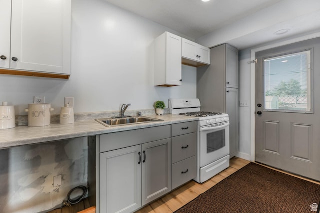 4281 W 5780 S, Salt Lake City, UT 84118 - kitchen featuring white range with gas cooktop, gray cabinetry, light wood-style flooring, and light countertops