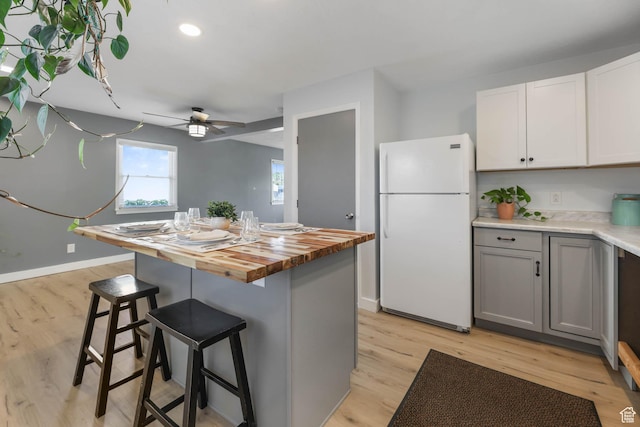 4281 W 5780 S, Salt Lake City, UT 84118 - kitchen with freestanding refrigerator, wooden counters, light wood finished floors, a breakfast bar, and recessed lighting