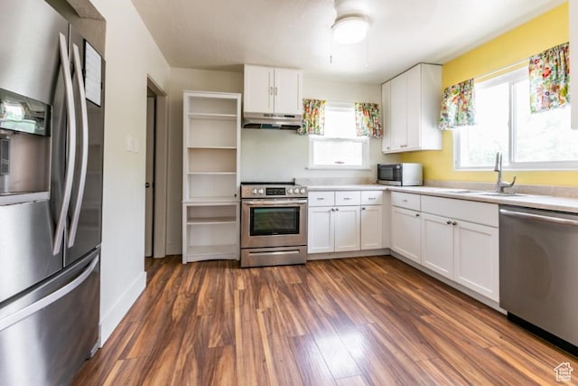 3071 Quincy Ave, Ogden, UT 84403 - kitchen with appliances with stainless steel finishes, under cabinet range hood, white cabinets, dark wood finished floors, and light countertops