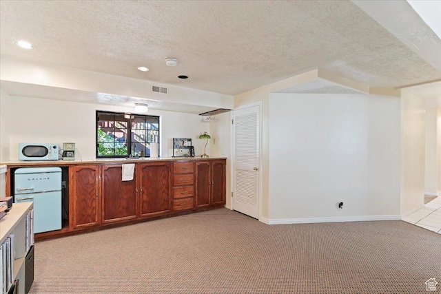 5791 S Oakwood Dr W, South Ogden, UT 84405 - kitchen with light carpet, a textured ceiling, white microwave, light countertops, and recessed lighting