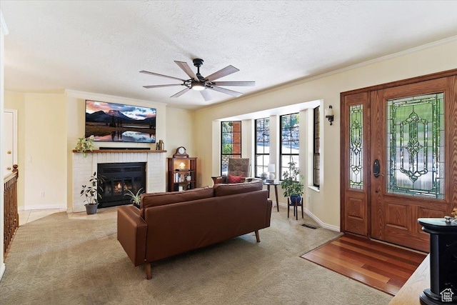 5791 S Oakwood Dr W, South Ogden, UT 84405 - living room with a ceiling fan, a brick fireplace, crown molding, a textured ceiling, and light carpet