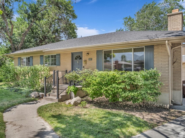 787 E Casa Blanco Cir, Midvale, UT 84047 - ranch-style house with brick siding, a chimney, roof with shingles, and a front yard