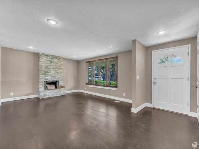 787 E Casa Blanco Cir, Midvale, UT 84047 - entrance foyer with a textured ceiling, a stone fireplace, dark wood-style floors, and recessed lighting