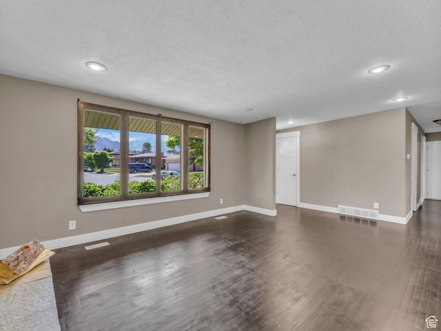 787 E Casa Blanco Cir, Midvale, UT 84047 - unfurnished living room featuring dark wood-style flooring, recessed lighting, and a textured ceiling