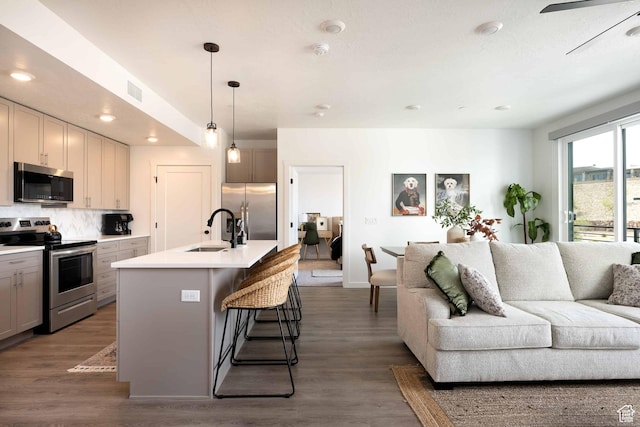 875 W Akoya Pearl St Unit 205, St George, UT 84790 - kitchen featuring stainless steel appliances, open floor plan, a breakfast bar, wood finished floors, and light countertops
