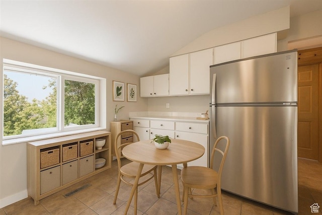 537 N Darwin St W, Salt Lake City, UT 84103 - kitchen with freestanding refrigerator, light countertops, vaulted ceiling, white cabinetry, and light tile patterned flooring