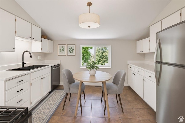 537 N Darwin St W, Salt Lake City, UT 84103 - kitchen with stainless steel appliances, lofted ceiling, light countertops, white cabinets, and tile patterned flooring