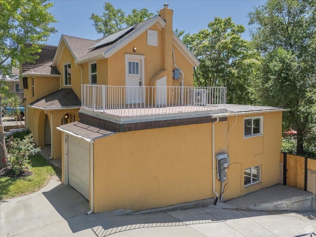537 N Darwin St W, Salt Lake City, UT 84103 - rear view of property with a balcony, solar panels, stucco siding, and a chimney