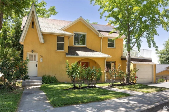 537 N Darwin St W, Salt Lake City, UT 84103 - view of front of home with stucco siding, roof mounted solar panels, a front yard, a balcony, and driveway