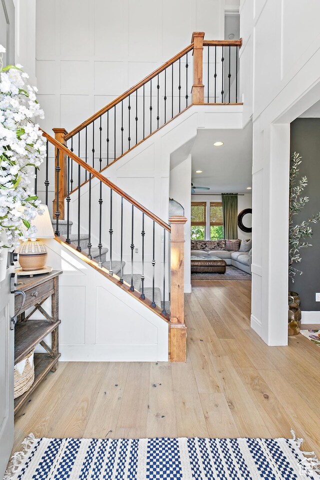 1471 S Sage Bloom Way, Saratoga Springs, UT 84045 - stairway featuring wood finished floors, a decorative wall, and a towering ceiling
