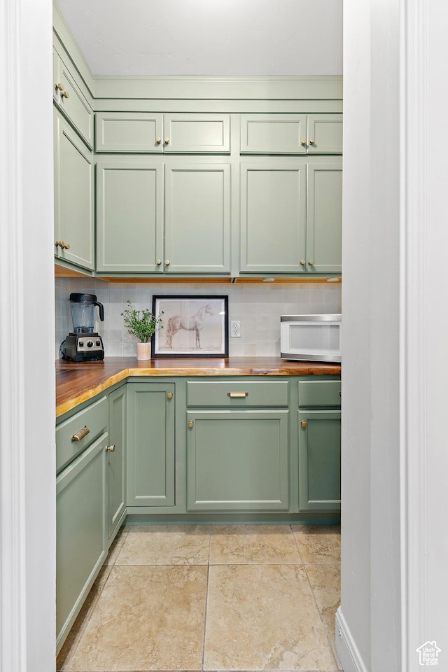 1471 S Sage Bloom Way, Saratoga Springs, UT 84045 - kitchen with green cabinets, wood counters, white microwave, and decorative backsplash