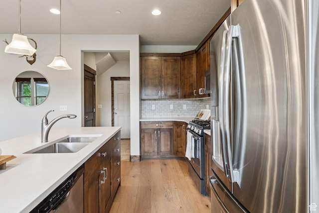 1046 W Abigail Dr, Heber City, UT 84032 - kitchen featuring stainless steel appliances, light wood finished floors, light countertops, tasteful backsplash, and hanging light fixtures
