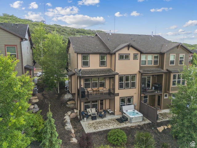 1046 W Abigail Dr, Heber City, UT 84032 - rear view of house with a patio area, an outdoor hangout area, roof with shingles, and a hot tub