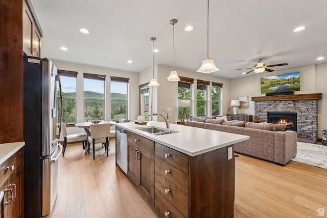 1046 W Abigail Dr, Heber City, UT 84032 - kitchen with appliances with stainless steel finishes, light wood-style flooring, light countertops, a fireplace, and recessed lighting