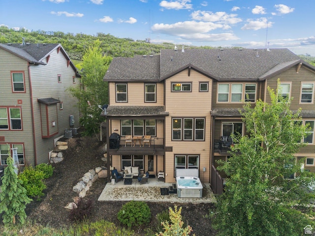 1046 W Abigail Dr, Heber City, UT 84032 - back of property featuring an outdoor hangout area, a patio, roof with shingles, and a hot tub