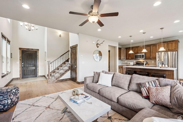 1046 W Abigail Dr, Heber City, UT 84032 - living room featuring recessed lighting, light wood-style floors, stairs, ceiling fan, and a chandelier