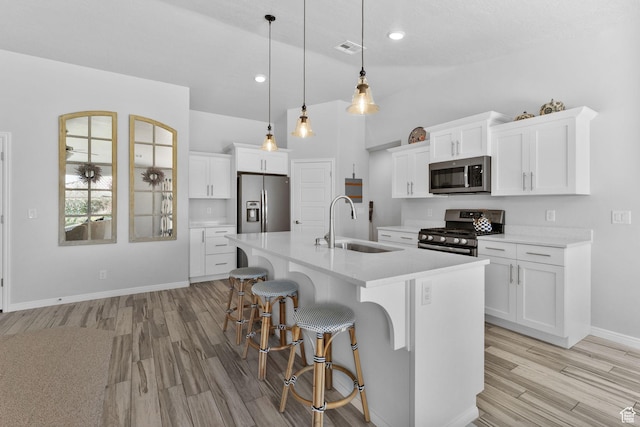 902 E 3950 S, Washington, UT 84780 - kitchen featuring stainless steel appliances, light wood-type flooring, a breakfast bar, light countertops, and a kitchen island with sink