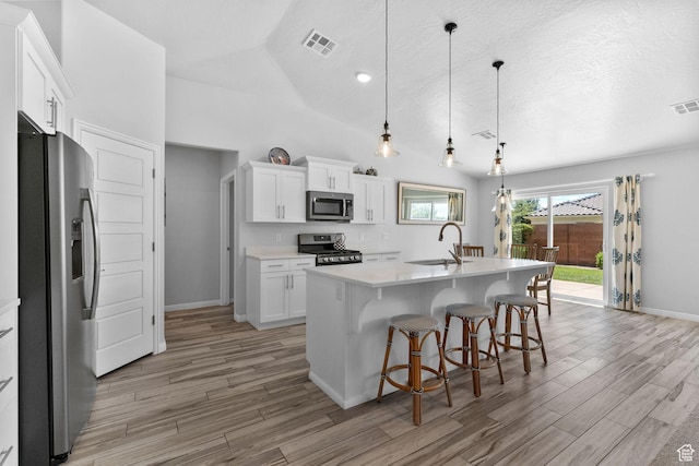 902 E 3950 S, Washington, UT 84780 - kitchen featuring appliances with stainless steel finishes, light wood-style flooring, light countertops, white cabinetry, and a breakfast bar area