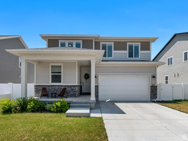 5451 N Yeager Ln, Eagle Mountain, UT 84005 - view of front of home with covered porch, a garage, concrete driveway, and stone siding