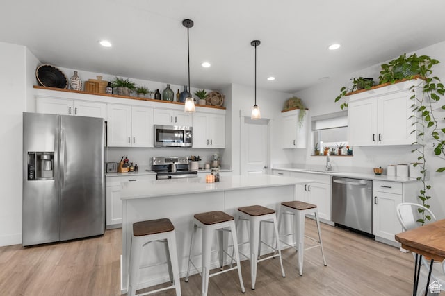 2122 W 1745th Ct S, West Haven, UT 84401 - kitchen with stainless steel appliances, light wood-type flooring, white cabinets, a breakfast bar area, and recessed lighting