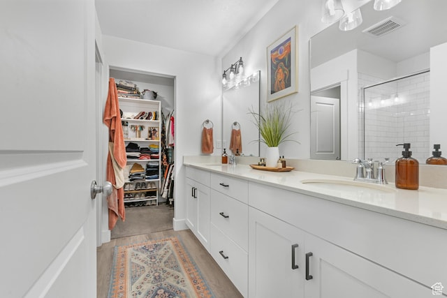 2122 W 1745th Ct S, West Haven, UT 84401 - bathroom featuring double vanity, a shower stall, a spacious closet, and wood finished floors