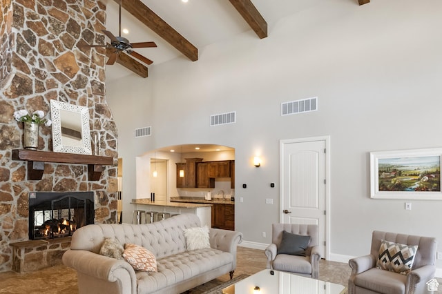 5529 W Sicily Ln N, Highland, UT 84003 - living area featuring a towering ceiling, a ceiling fan, a stone fireplace, beam ceiling, and arched walkways