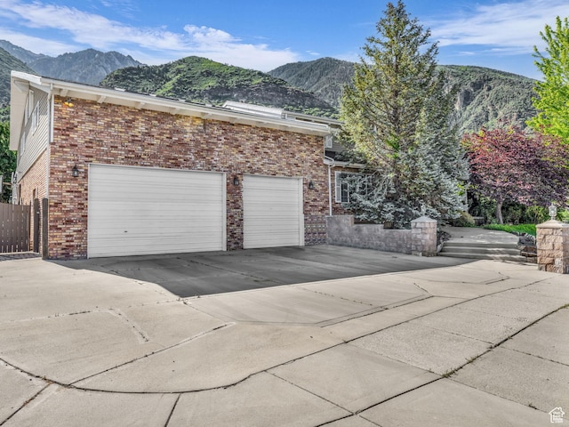 11551 S Woodhampton Dr E, Sandy, UT 84092 - view of side of property with a mountain view, concrete driveway, and brick siding