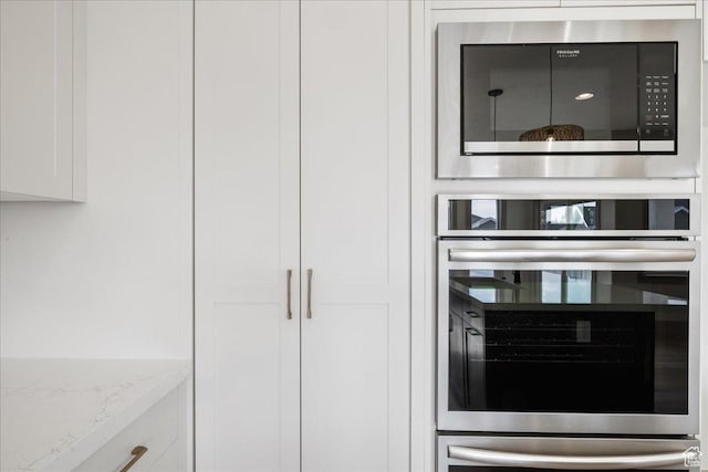 954 S Sandy Ln, Spanish Fork, UT 84660 - kitchen view of oven, black microwave, white cabinetry, and light stone countertops