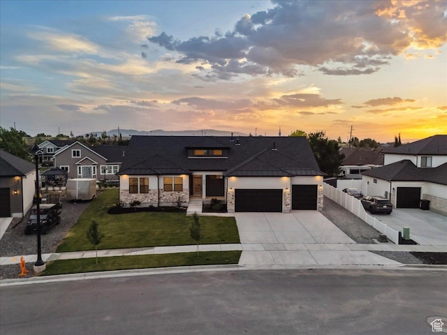 954 S Sandy Ln, Spanish Fork, UT 84660 - view of front of home featuring stone siding, an attached garage, driveway, and a front lawn