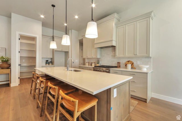 551 W Summerhill Ln, Centerville, UT 84014 - kitchen with decorative backsplash, a center island with sink, light wood-style floors, light countertops, and a breakfast bar